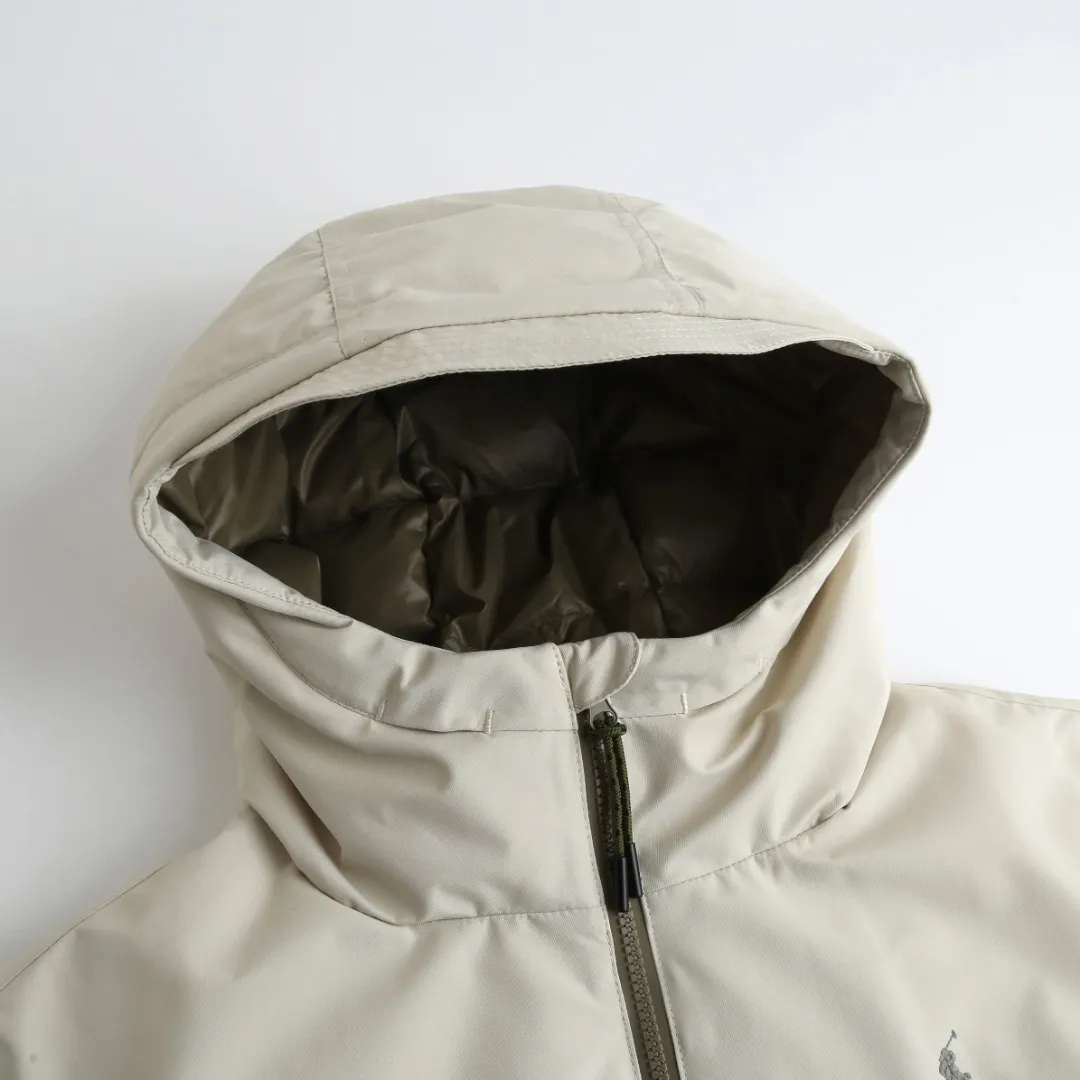 P970 Ralph Lauren Logo Hooded Down Jacket Fabric selection: High-density nylon taffeta with a density of about 210T-300T, smooth and slightly matte surface, excellent windproof and waterproof performance (with DWR water-repellent treatment), strong wrinkle resistance and easy care, in line with the "durable and practical" positioning of American leisure.  Lining fabric: 100% polyamide is used to create the lining. The high-density and tight weaving process prevents fine lint from emerging from the gaps in the fabric. The smooth surface improves the putting on and taking off experience, and the excellent wear and tear resistance ensures damage caused by frequent use, while the light and soft texture does not affect the overall weight.  High-quality filling: 90 white duck down is selected, with a weight of 220g, ensuring excellent thermal insulation performance. After strict screening and processing, the velvet is not easy to drill, ensuring durability. Style and cutting process: The classic jacket has a slightly loose fit, with a slightly dropped shoulder line (the shoulder width is 1-2cm wider than the standard fit). The length reaches the hips, and the sleeves are slightly tapered straight sleeves, taking into account freedom of movement and casual style.  Details: The adjustable Velcro on the cuffs allows you to freely adjust the tightness according to the thickness of your wrist and personal preferences, effectively preventing cold wind from intruding, and improving warmth retention performance.  In terms of storage, the two front zipper pockets are convenient for you to place frequently used items, and the zipper design ensures that items are not easily lost. A built-in pocket on the left side of the chest provides a safe storage space for some small private items.  The drawstring design at the hem allows you to adjust the shape of the jacket according to your body shape and dressing needs. Whether it is loose and casual or slim and neat, you can easily control it.  Embroidery technology: Polo horse logo on the left chest: flat satin stitch embroidery (satin embroidery), embroidery thread: 100% polyester high color fastness embroidery thread (the color number is consistent with the brand’s standard red color card), stitch density 12-15 stitches/cm, the outline of the horse logo is clear, and the details of the rider and horse are burr-free.  Embroidery positioning: precise positioning through the template (12cm from the neckline and 8cm from the placket) to ensure left and right symmetry and centering.  Accessories: One-to-one customized zipper sling, one-to-one customized zipper puller, one-to-one customized washable label SIZE: S M L XL